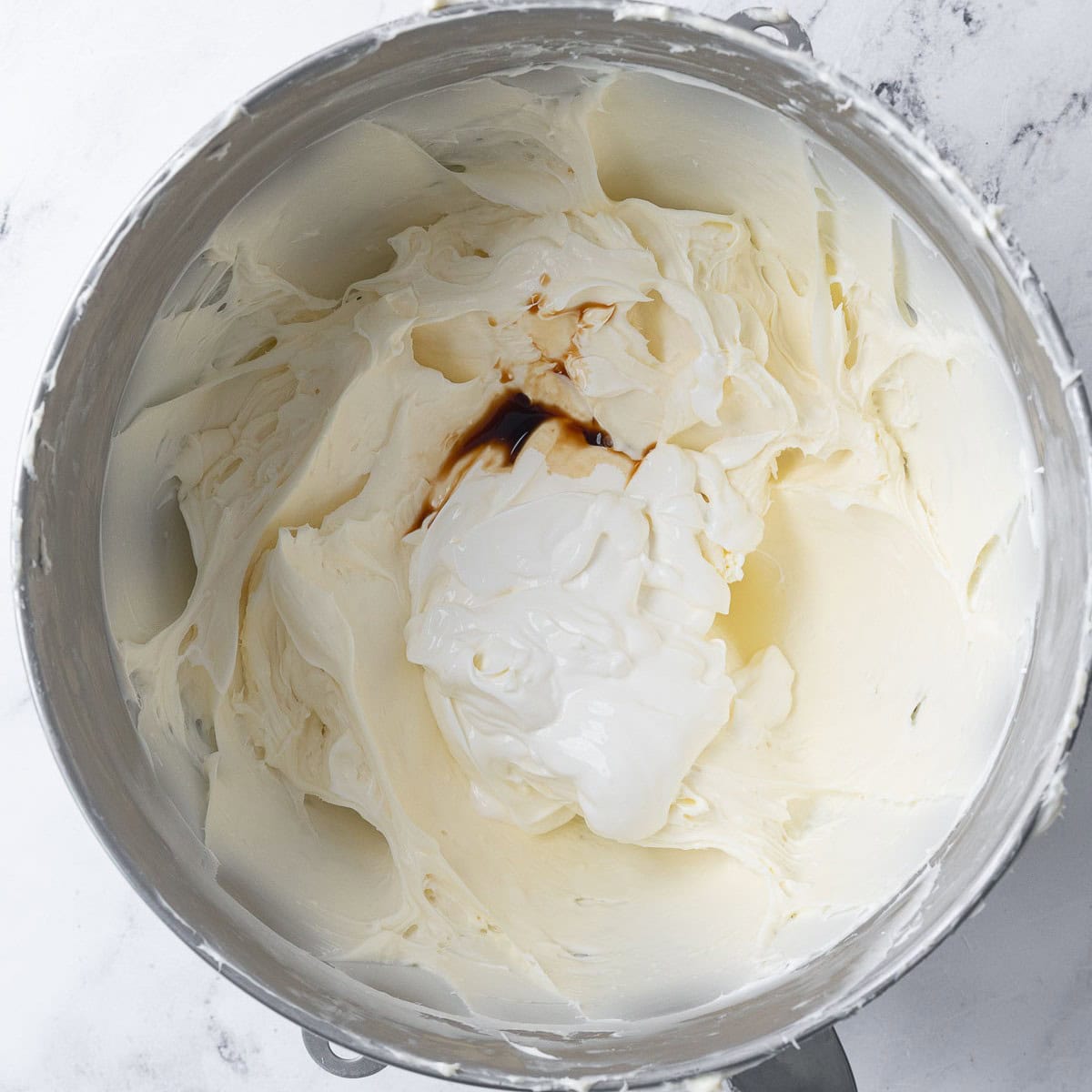 After creaming with sour cream, vanilla, and salt added before mixing.