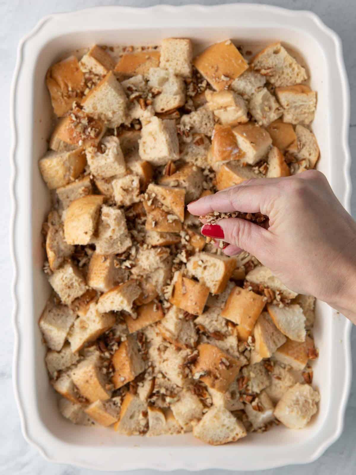Sprinkling pecans on top.