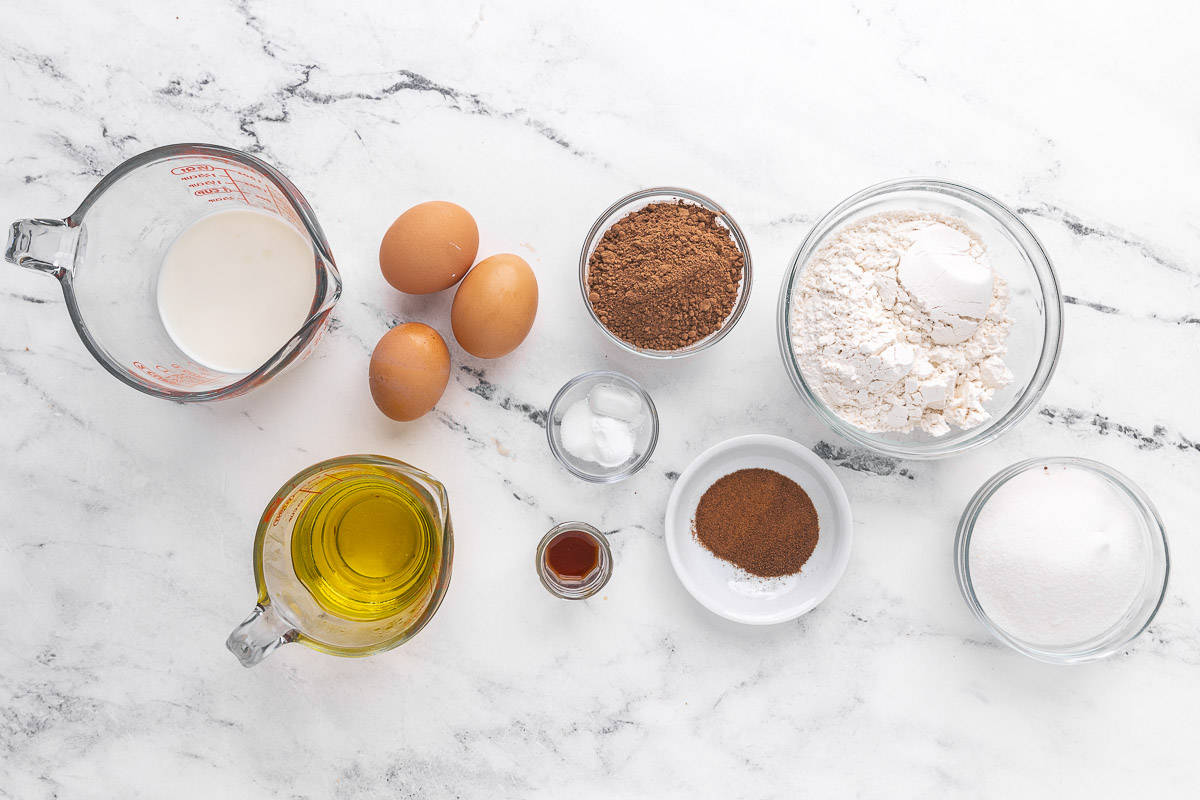 Ingredients for making the recipe: Flour, sugar, cocoa powder, instant espresso powder, baking powder, baking soda, salt, olive oil, milk, eggs, and vanilla extract.