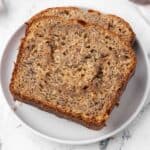 Closeup of 2 pieces of cinnamon swirl banana bread on a white plate.