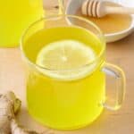 Ginger tea in a glass mug with lemon.
