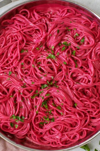 Pink beet pasta in skillet.