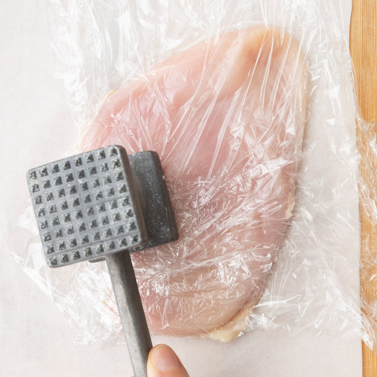 Mallet pounding a chicken breast.