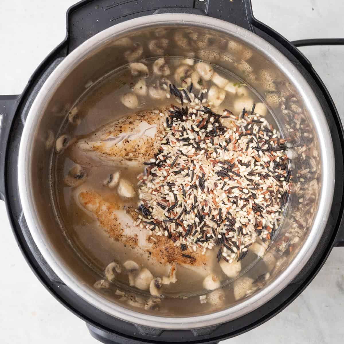 Stock rice and chicken added before stirring.