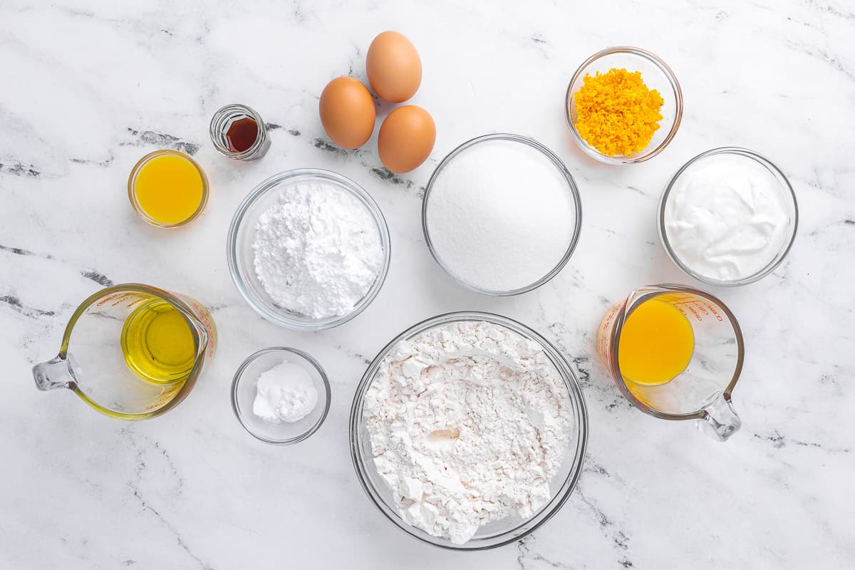 Ingredients to make recipe: Flour, baking powder, baking soda, salt, orange zest, sugar, eggs, olive oil, Greek yogurt, fresh orange juice, vanilla extract.