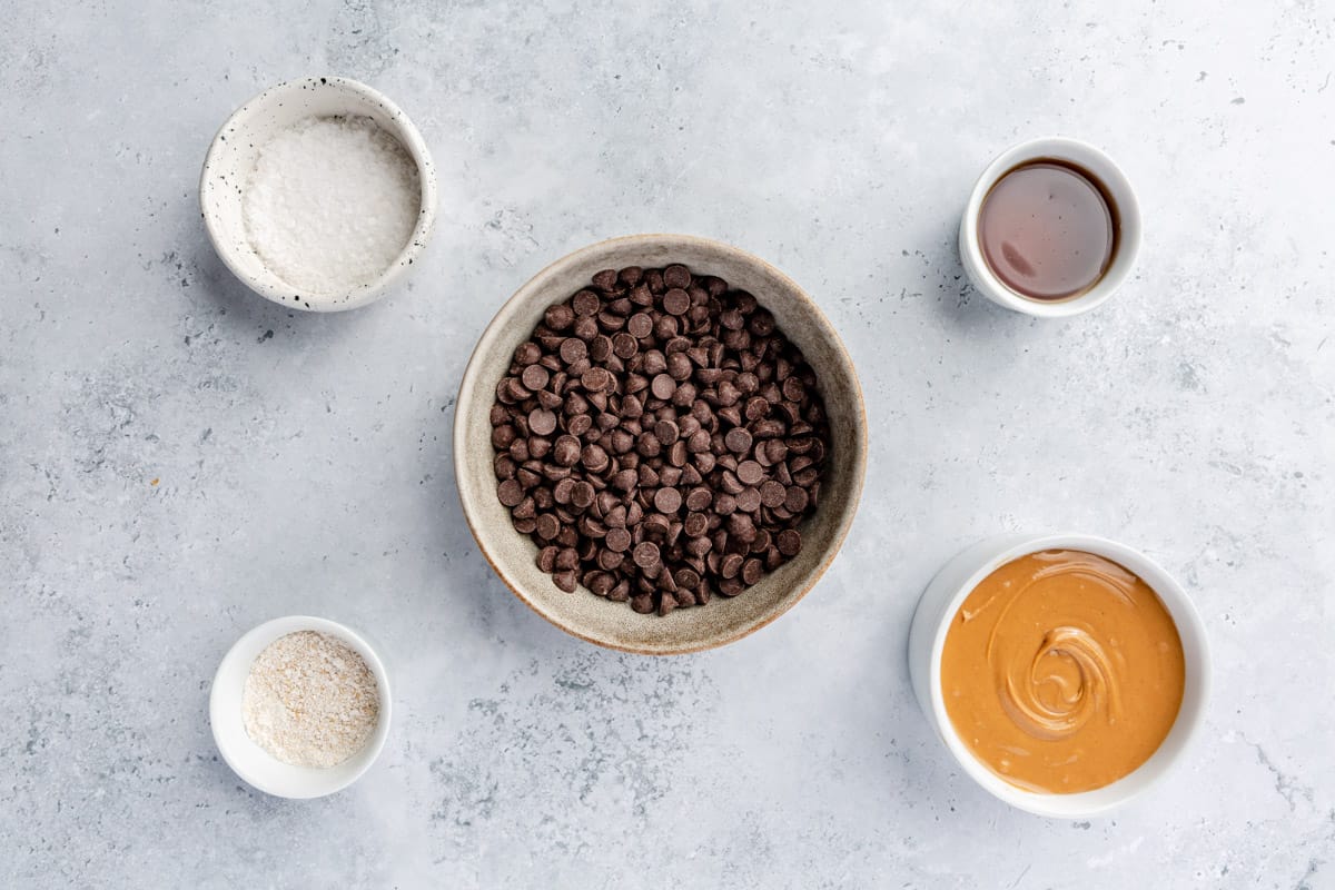 Ingredients for recipe: Chocolate chips, peanut butter, maple syrup, oat flour, and flaky salt.