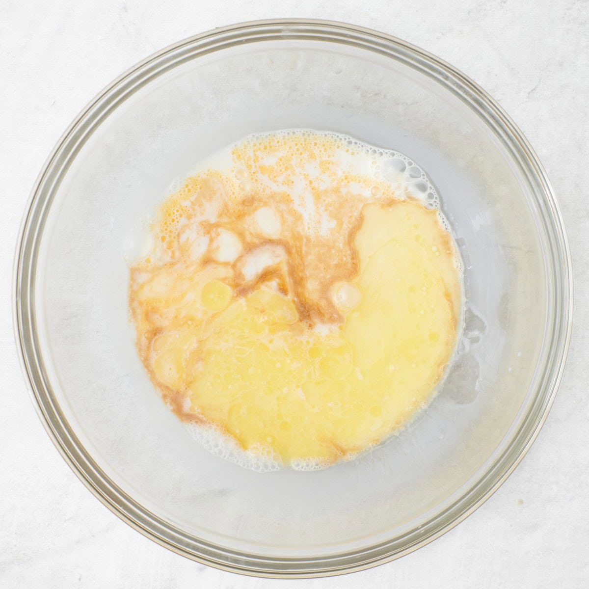 Wet ingredients for the pancakes added to the bowl with the egg.