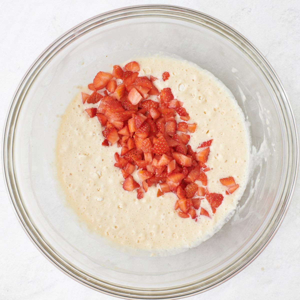 Strawberries added to the bowl of batter.