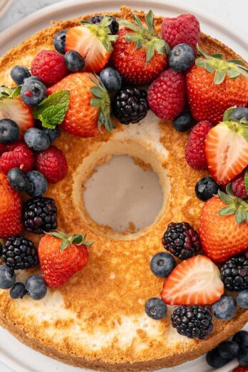 Homemade angel food cake topped with fresh berries.