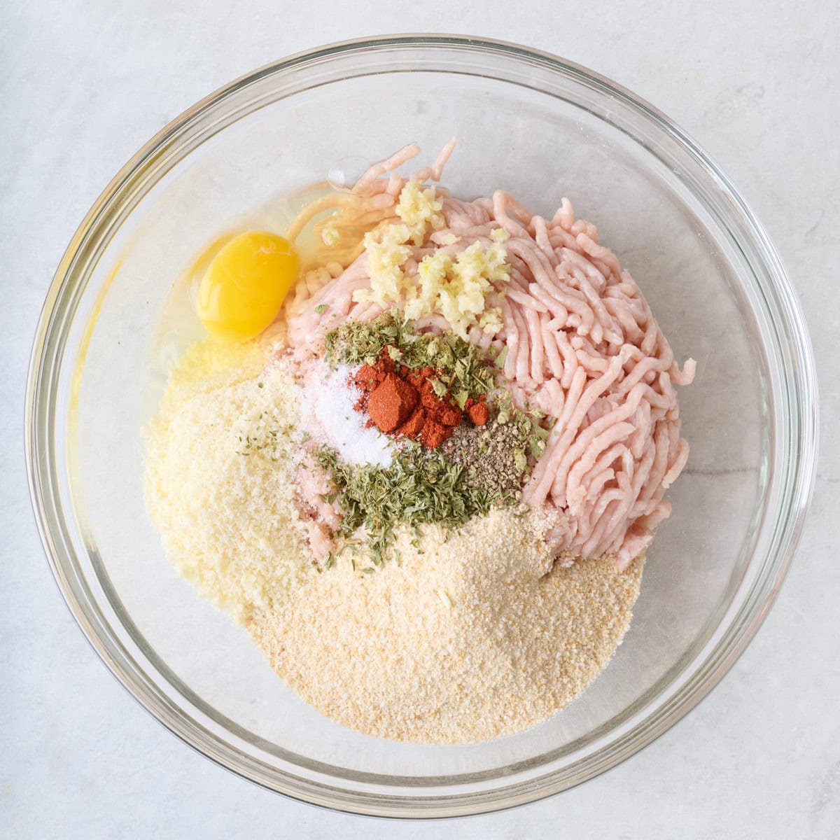 Ground chicken, parm, breadcrumbs, eggs, garlic, and seasonings in a large bowl before combining.