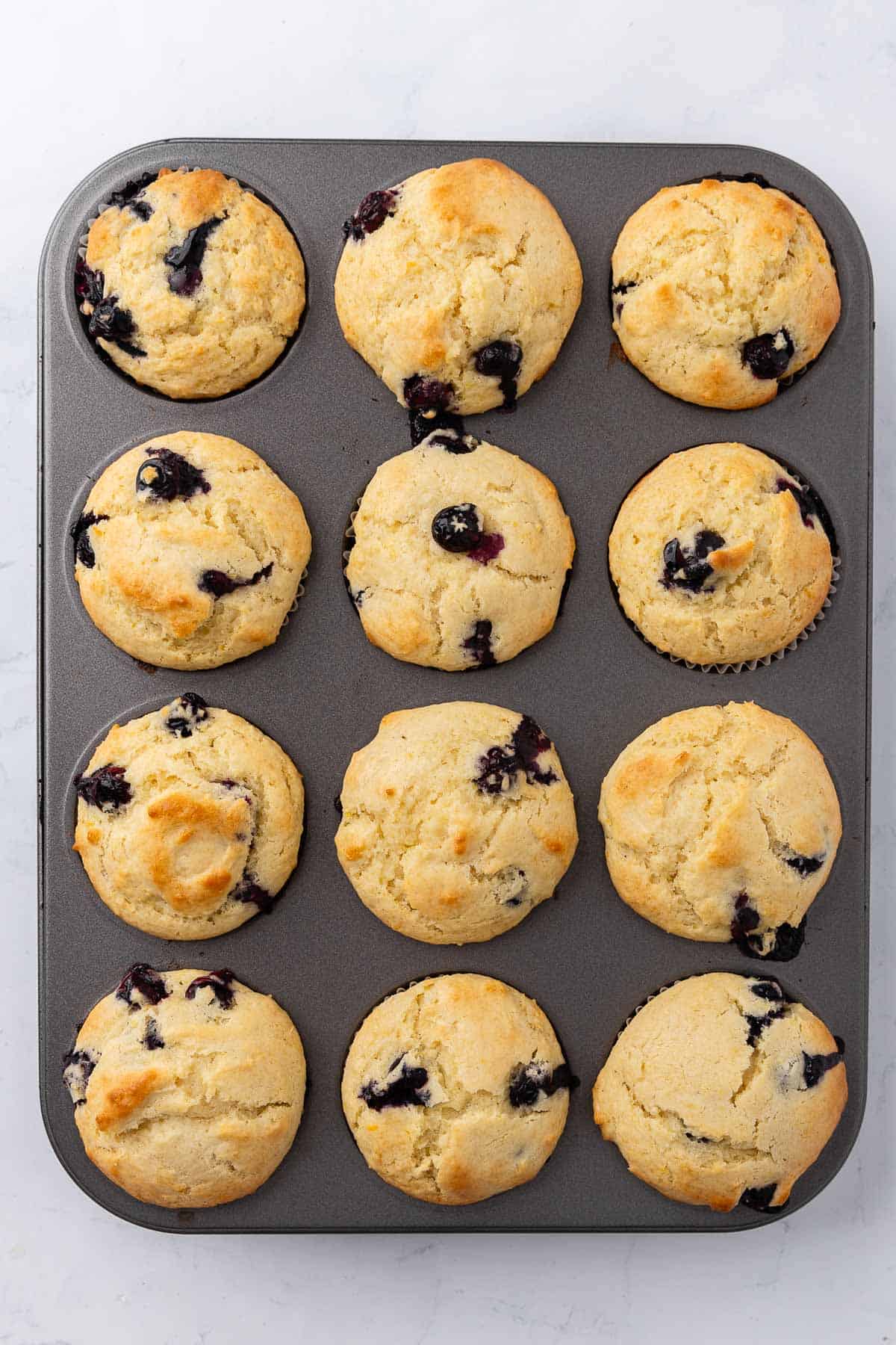Baked Lemon Blueberry Muffins in a 12-cup muffin tin.