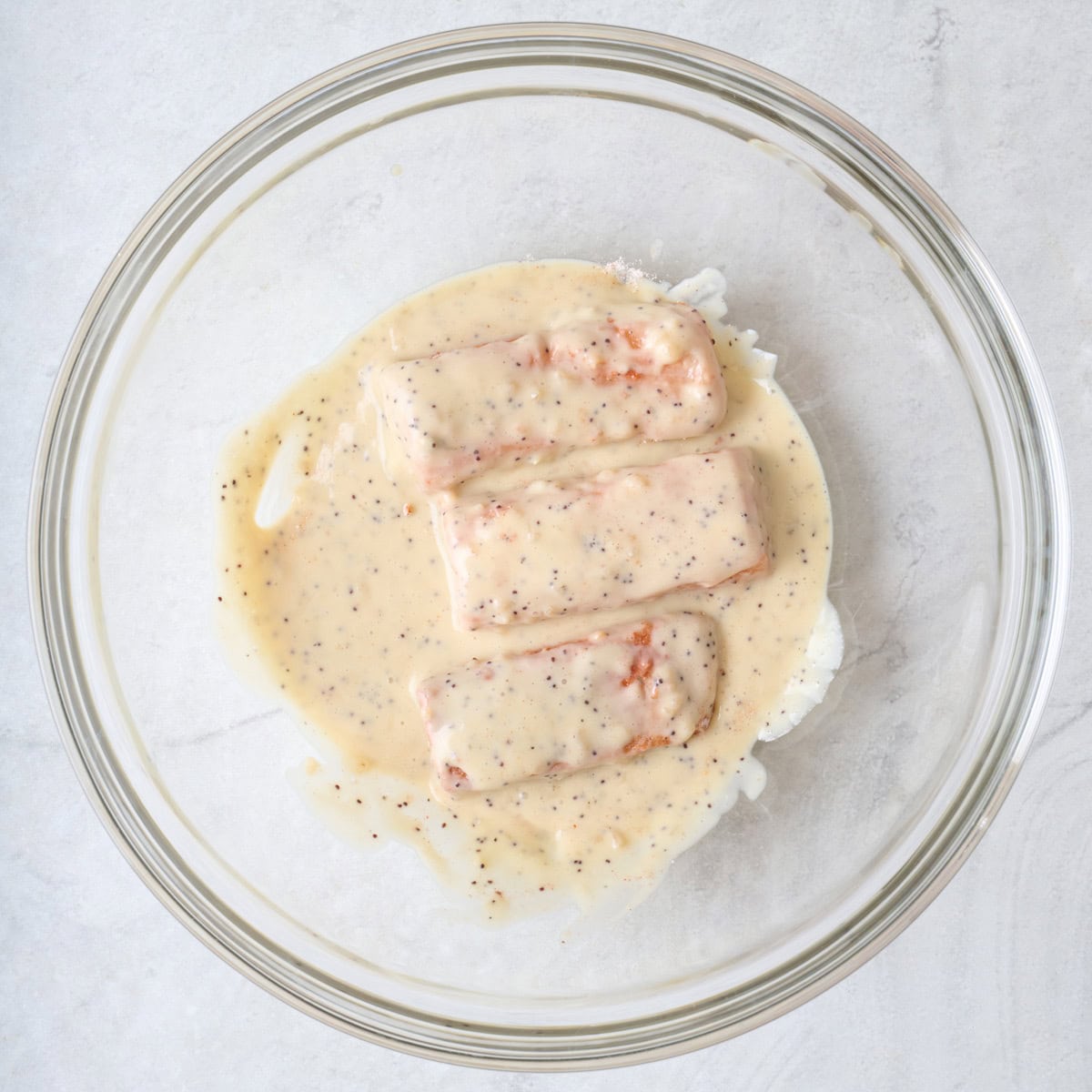 Raw salmon sticks coated in creamy sauce.