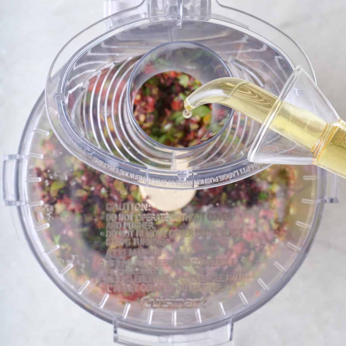 Oil being poured into food processor.