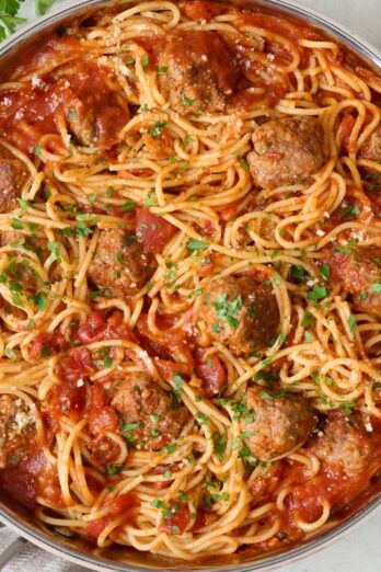 Spaghetti and meatballs after tossing together in skillet.