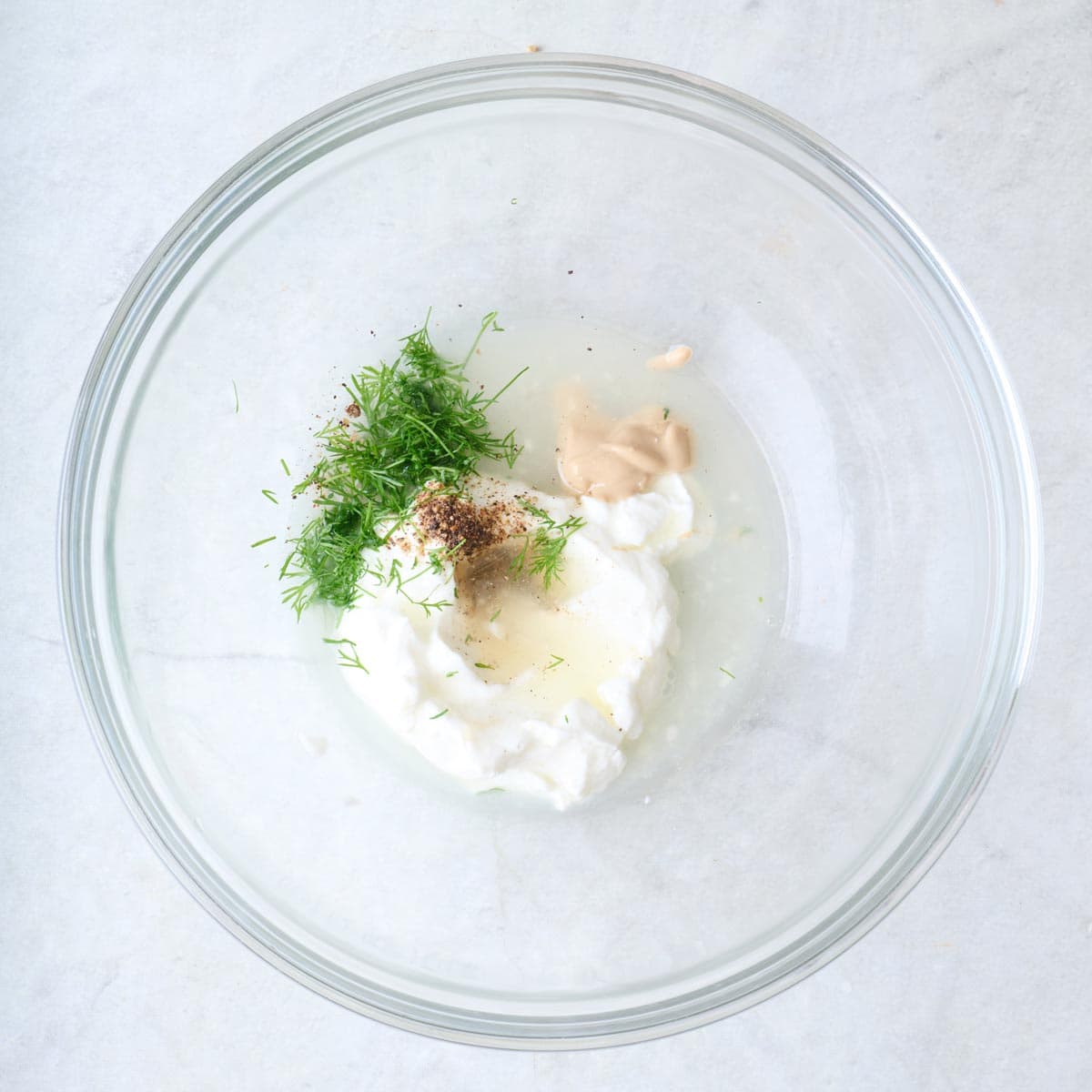 Dressing ingredients in a bowl before mixing.