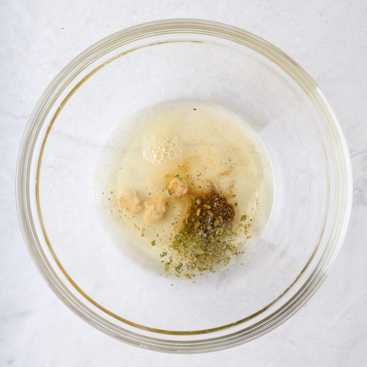 Dressing ingredients in a bowl before mixing.