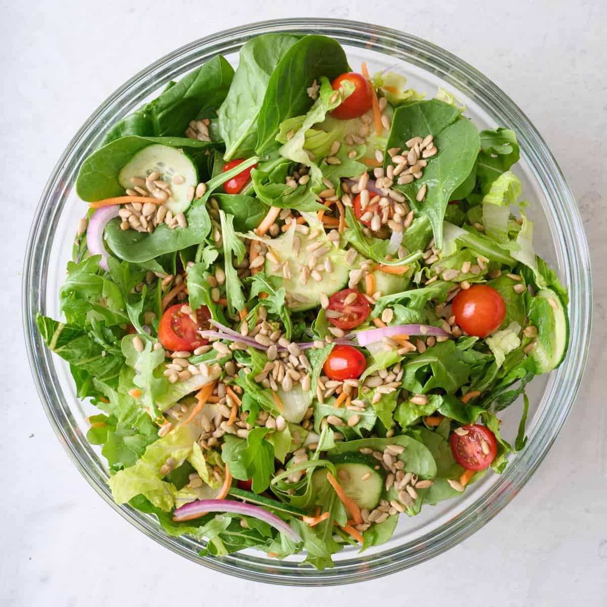 Mixed greens and vegetables topped with sunflower seeds.