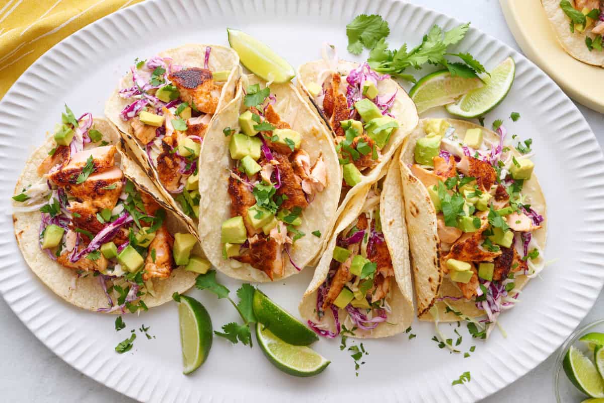 salmon tacos on a plate with lime wedges
