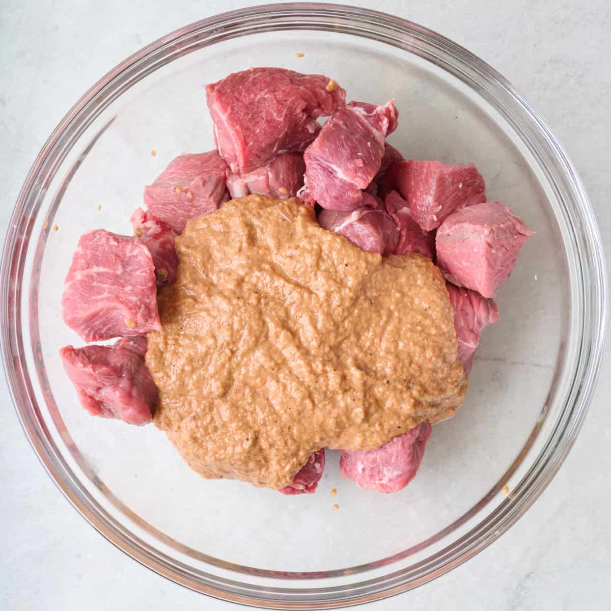 Cubed steak in a bowl with marinade.