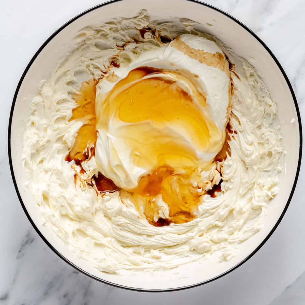 Cream cheese, yogurt, honey, and vanilla extract in a mixing bowl.