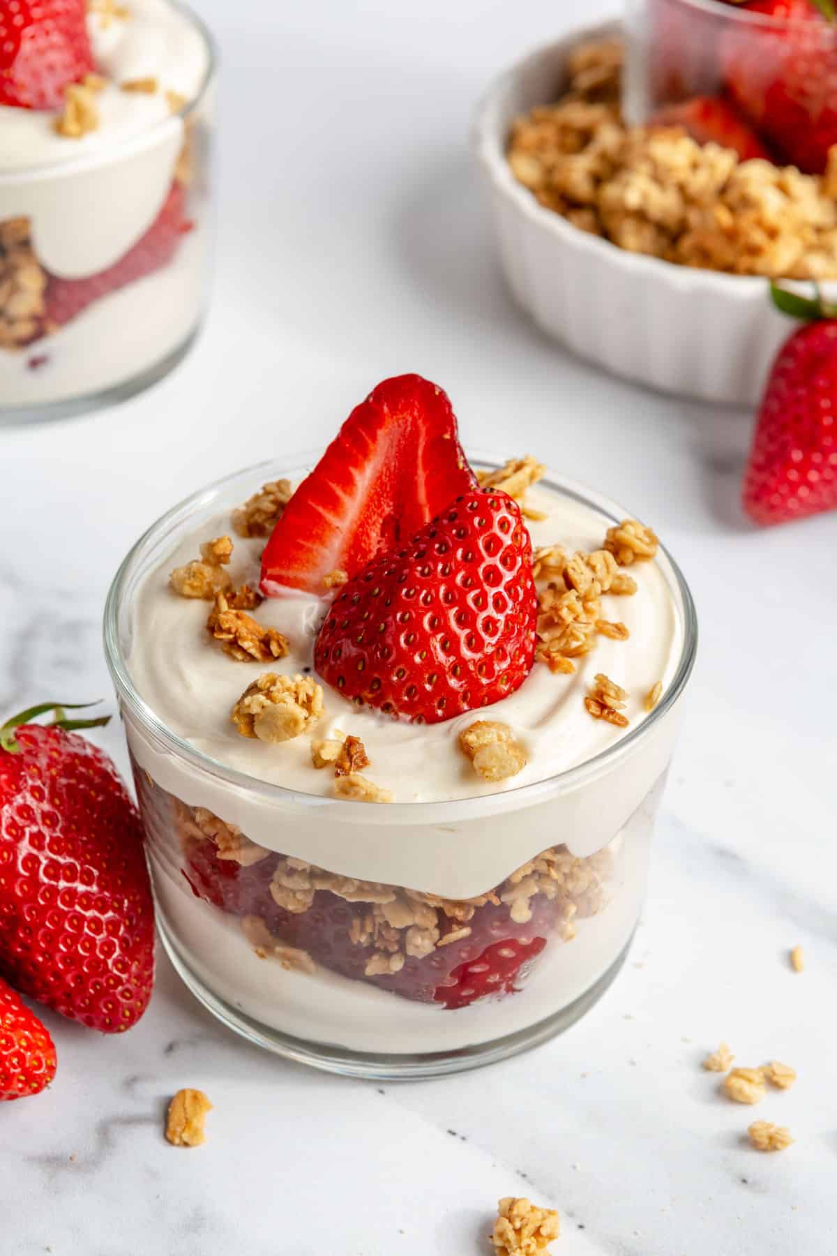 A strawberry parfait on a marble countertop.