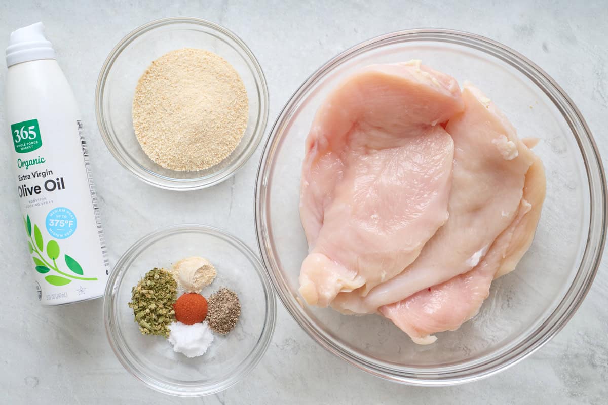 Ingredients for recipe: olive oil spray, breadcrumbs, seasonings, and chicken.