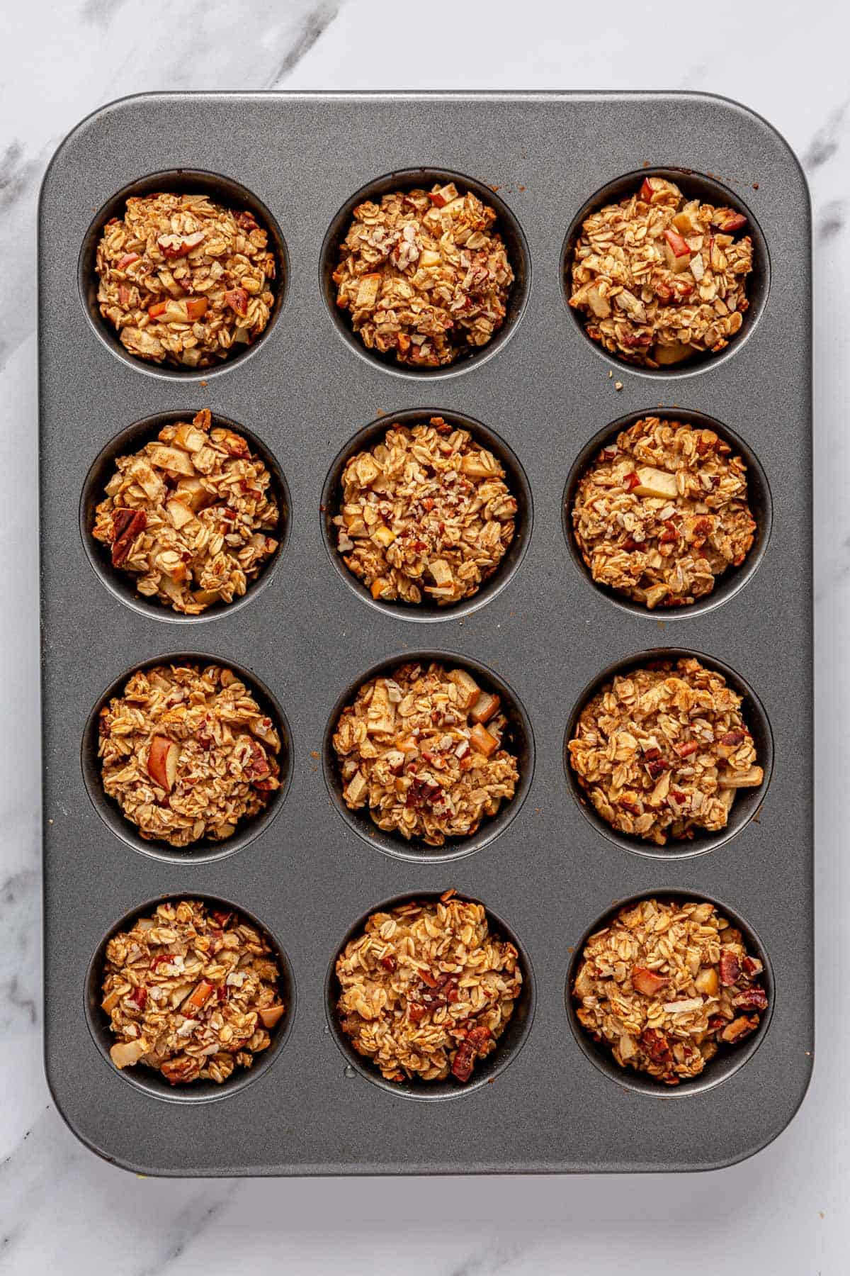Muffin cups in a muffin pan after baking and golden.