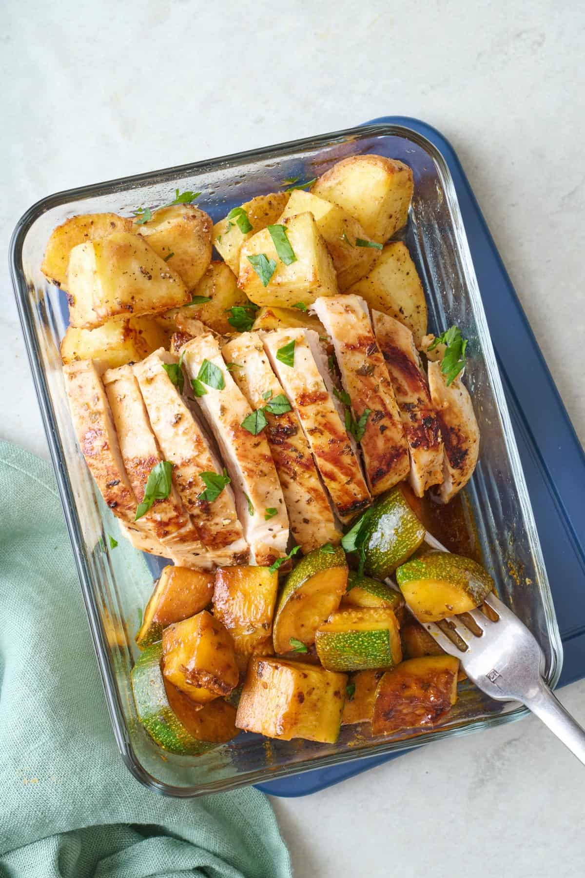 Lemon garlic meal prep container with seasoned potatoes and zucchini.