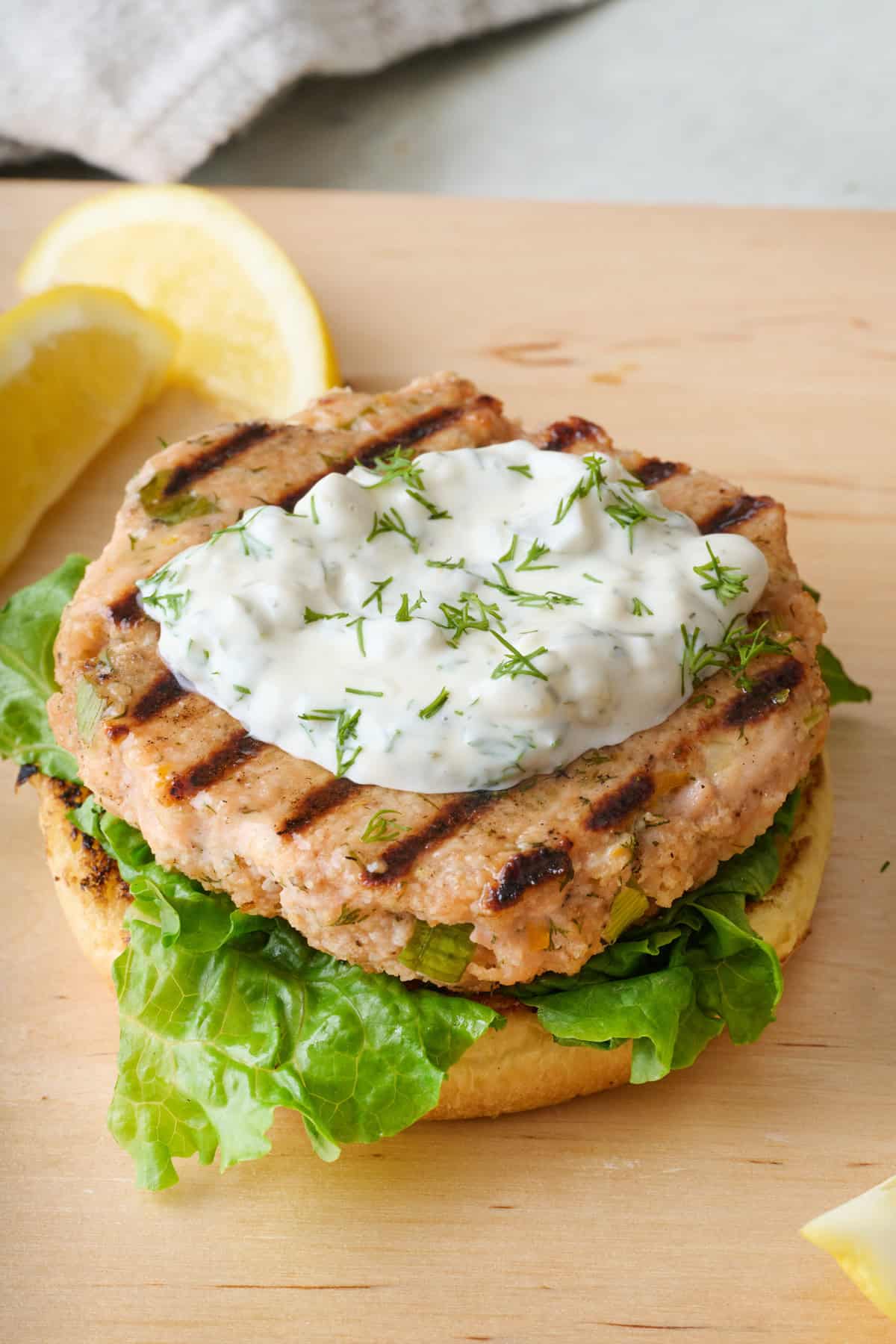 Recipe for how to make tartar sauce showing the homemade sauce on an open-faced salmon burger.