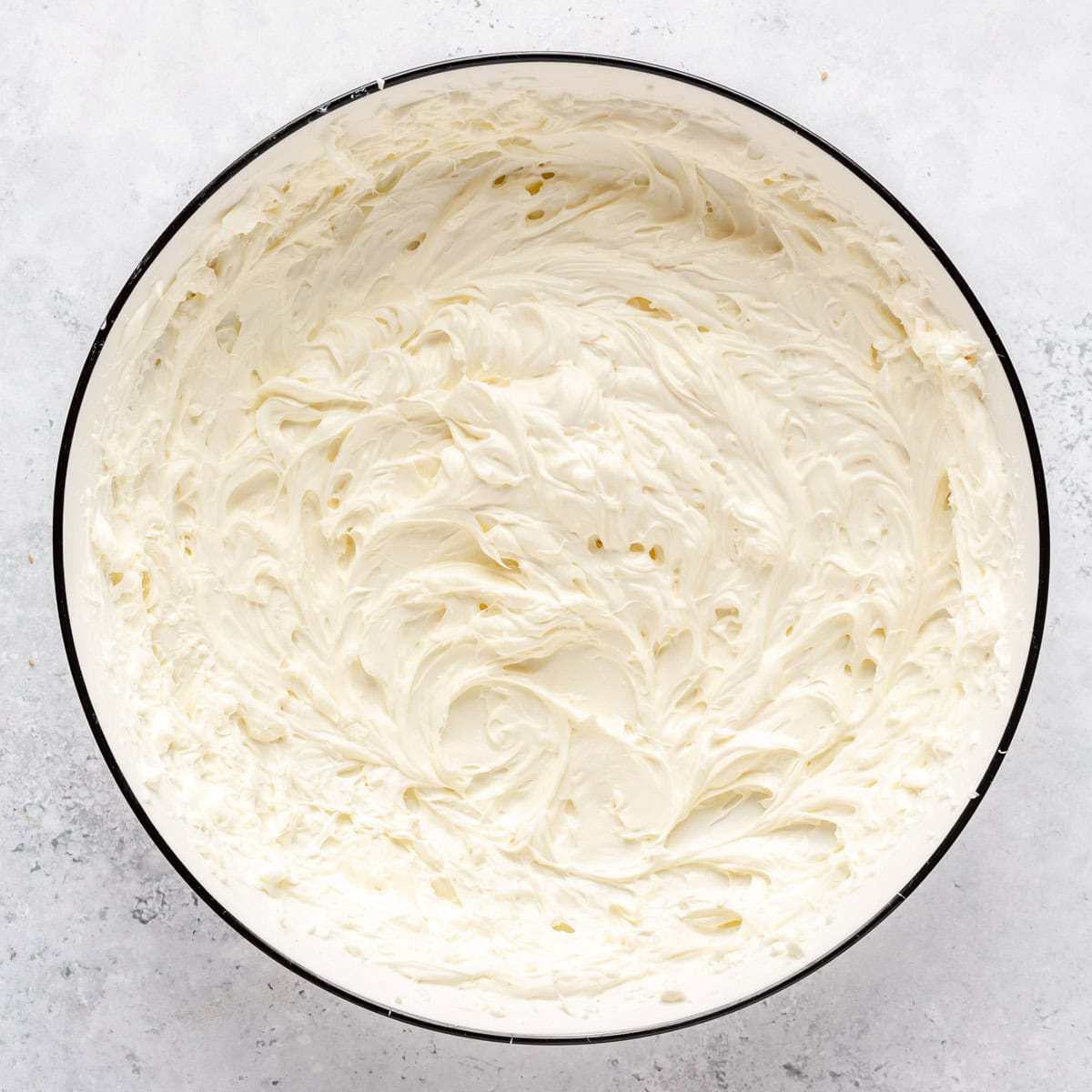 Cream cheese in a bowl after mixing until light and fluffy.