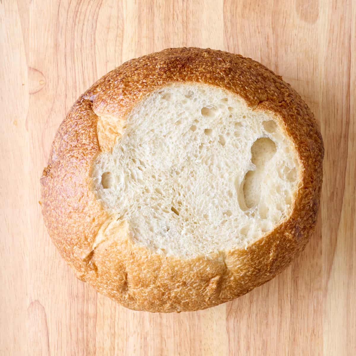 Bread on a cutting board with the top sliced off.