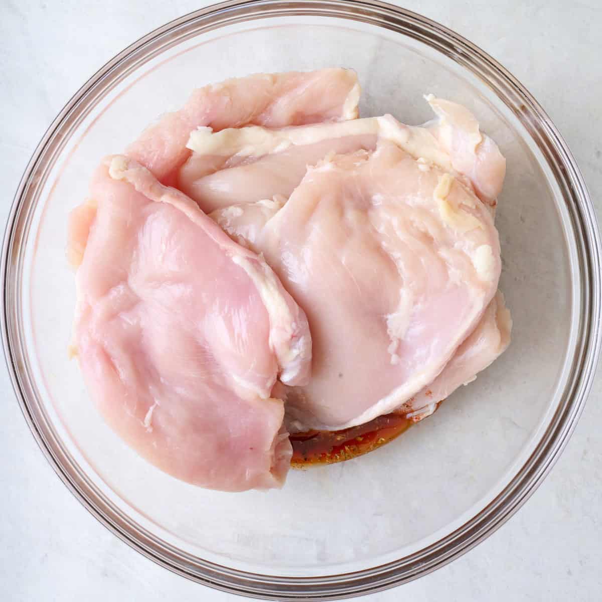 Chicken added on top of seasoned oil.