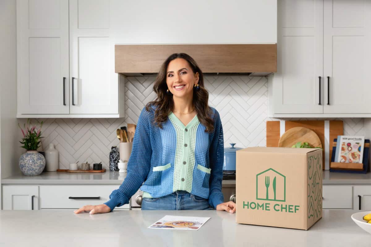 Yumna in kitchen with HomeChef box and meal.
