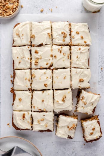 Easy carrot cake recipe cut into 20 squares on parchment paper.