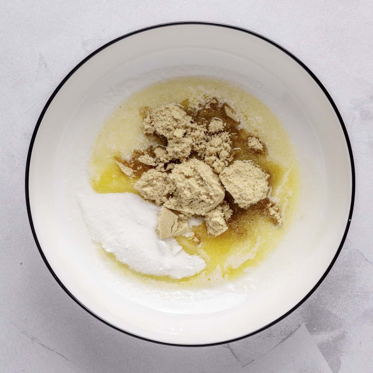 Melted butter in a bowl with sugars added.