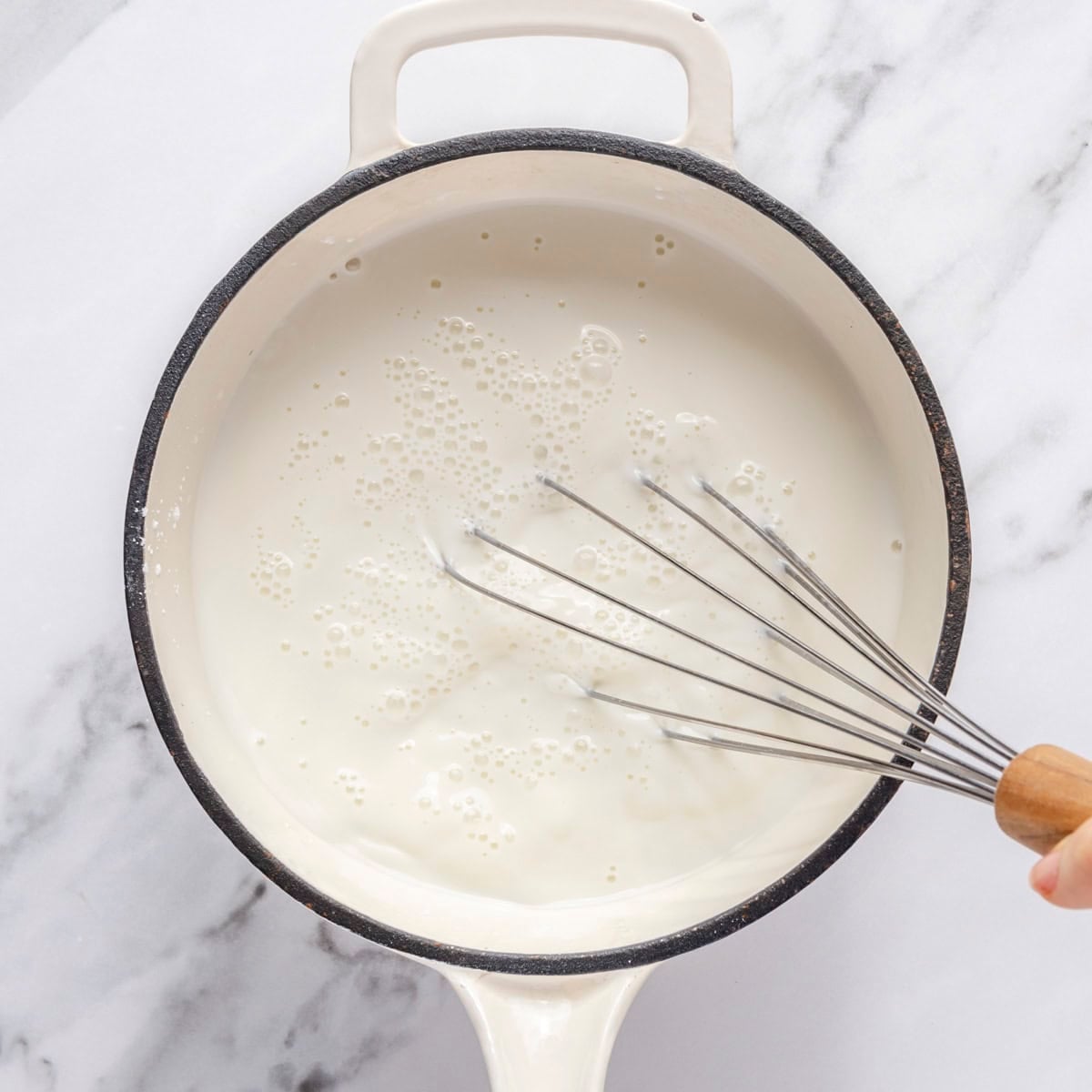 Whisking milk, sugar and cornstarch in saucepan.
