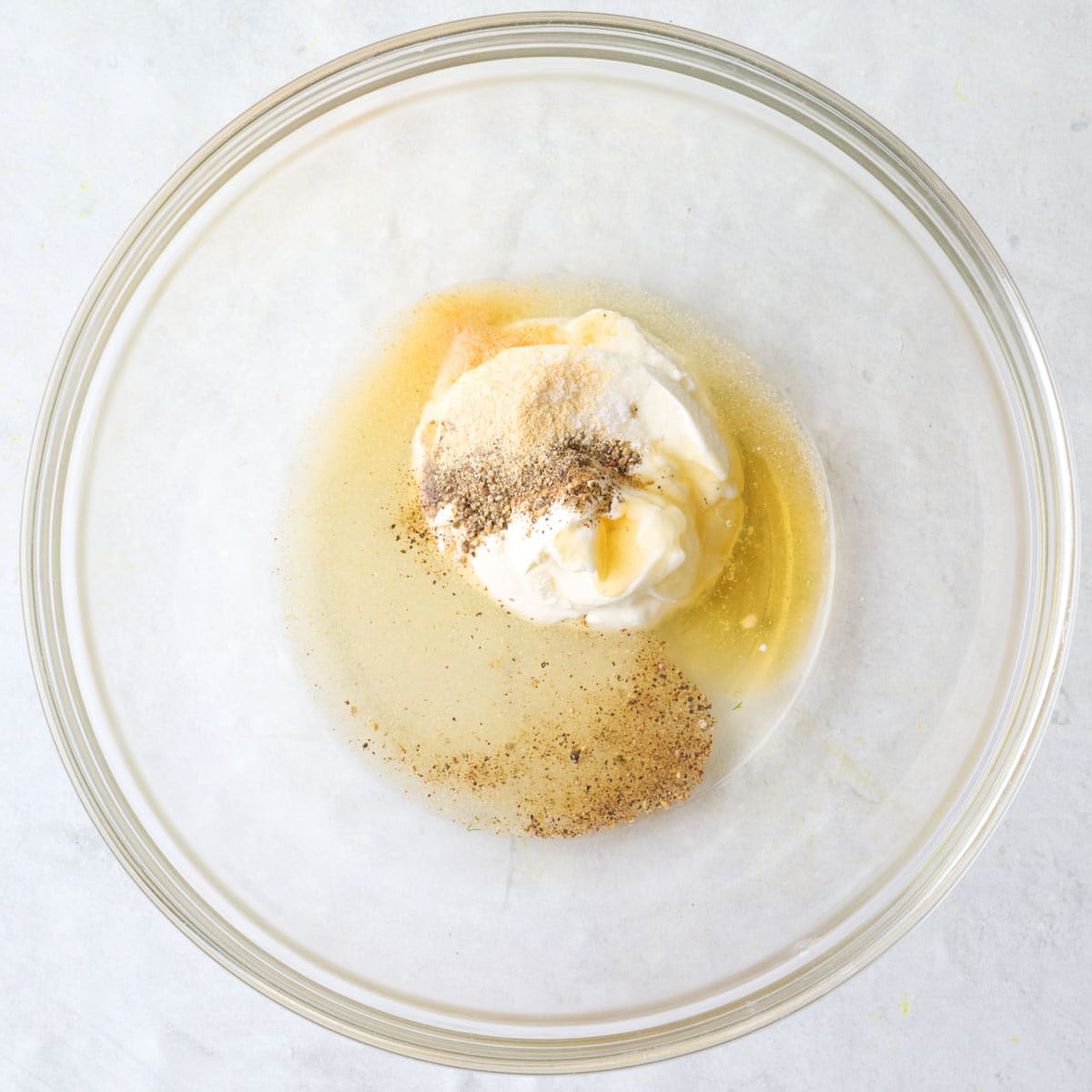 Sour cream, pickle juice and spices in a bowl.