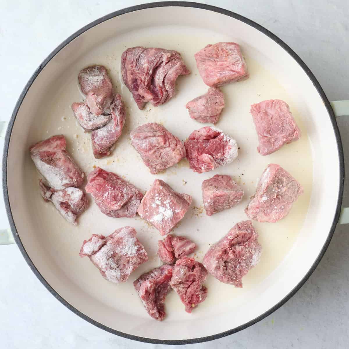 Flour coated stew meat in a hot oiled skillet.