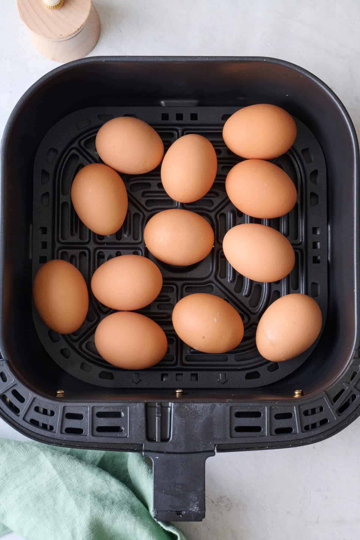 Whole air fryer eggs in an air fryer basket.