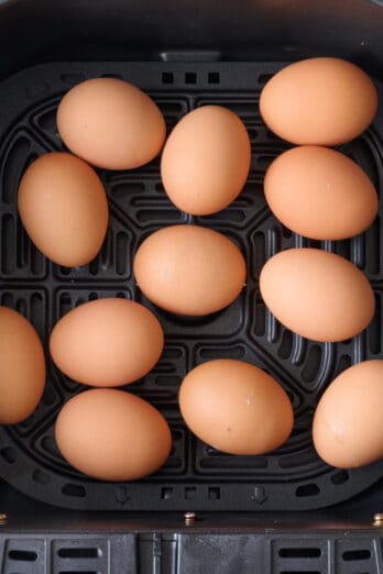Whole eggs in air fryer basket after cooking.