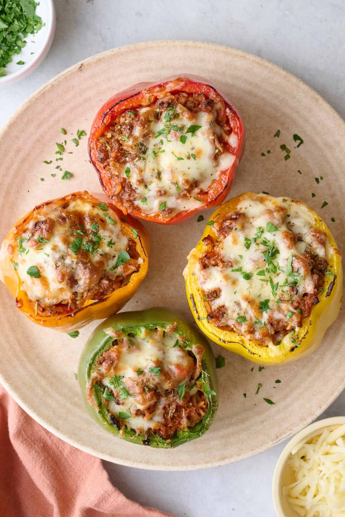 Air fried beef stuffed peppers with melted cheese on a large round platter.