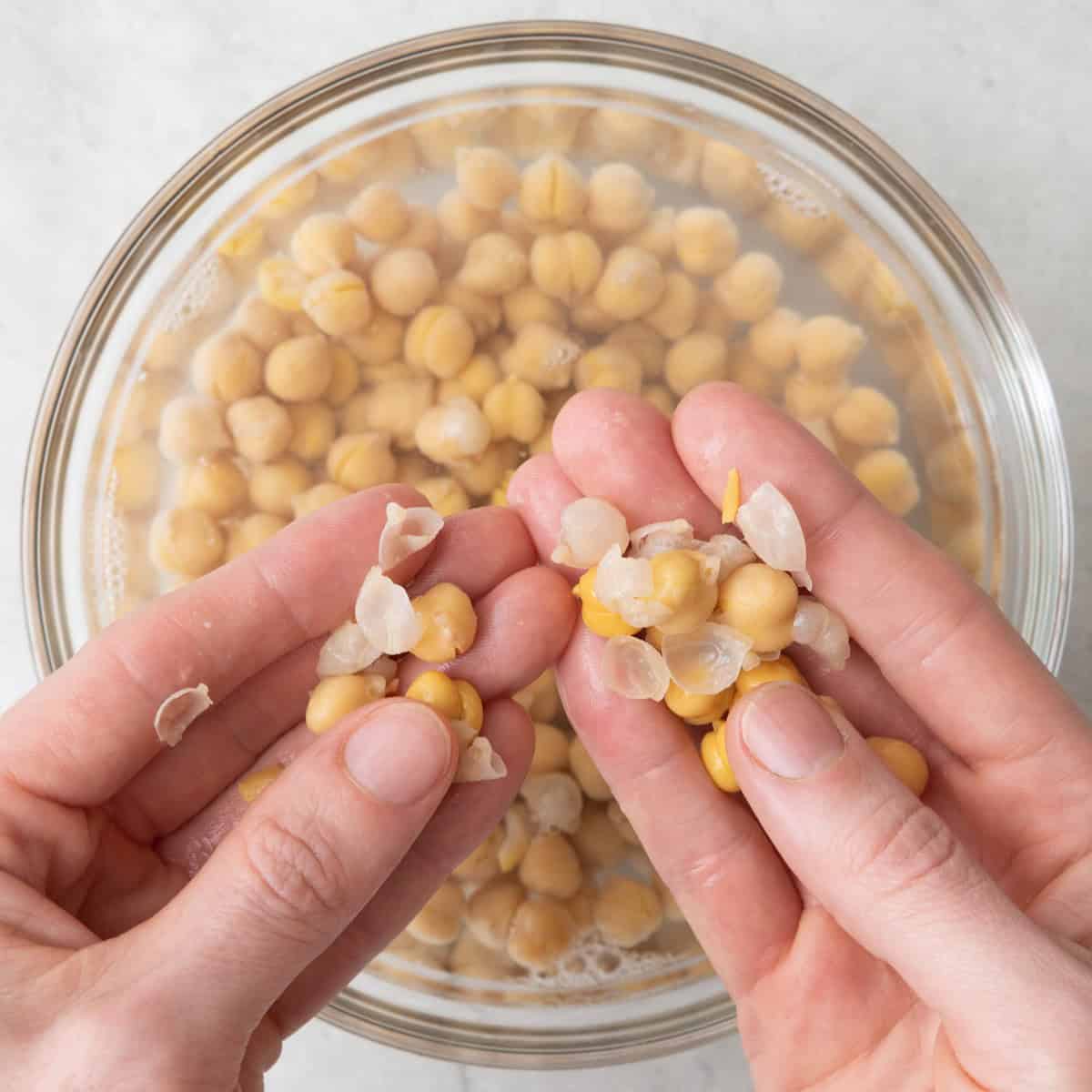 Handing removing skins from chickpeas.
