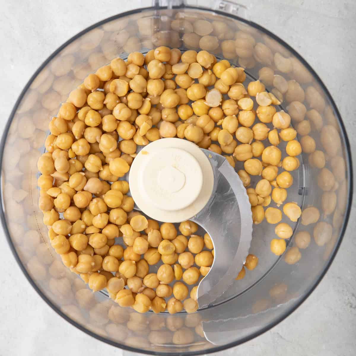 Peeled chickpeas in the bowl of a food processor.