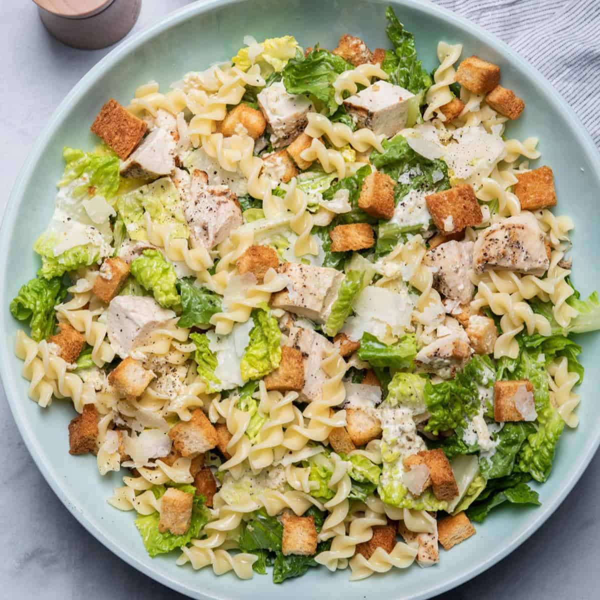 Bowl with all the ingredients and dressing getting poured on top.