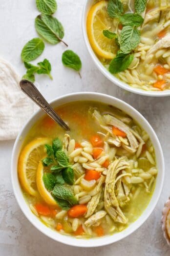 Chicken lemon orzo soup in two bowls.