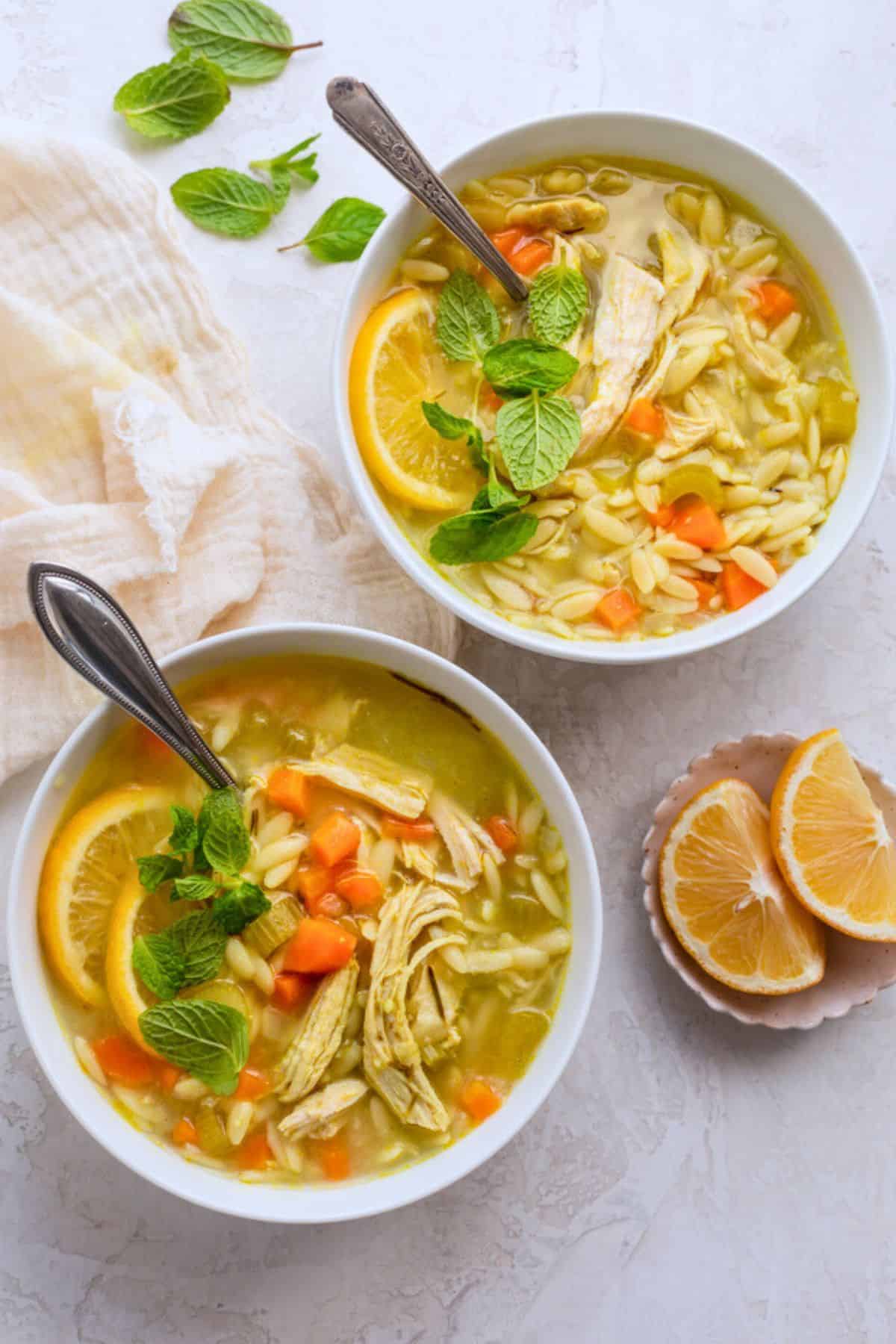 Easy lemon chicken soup with orzo served in two bowls.
