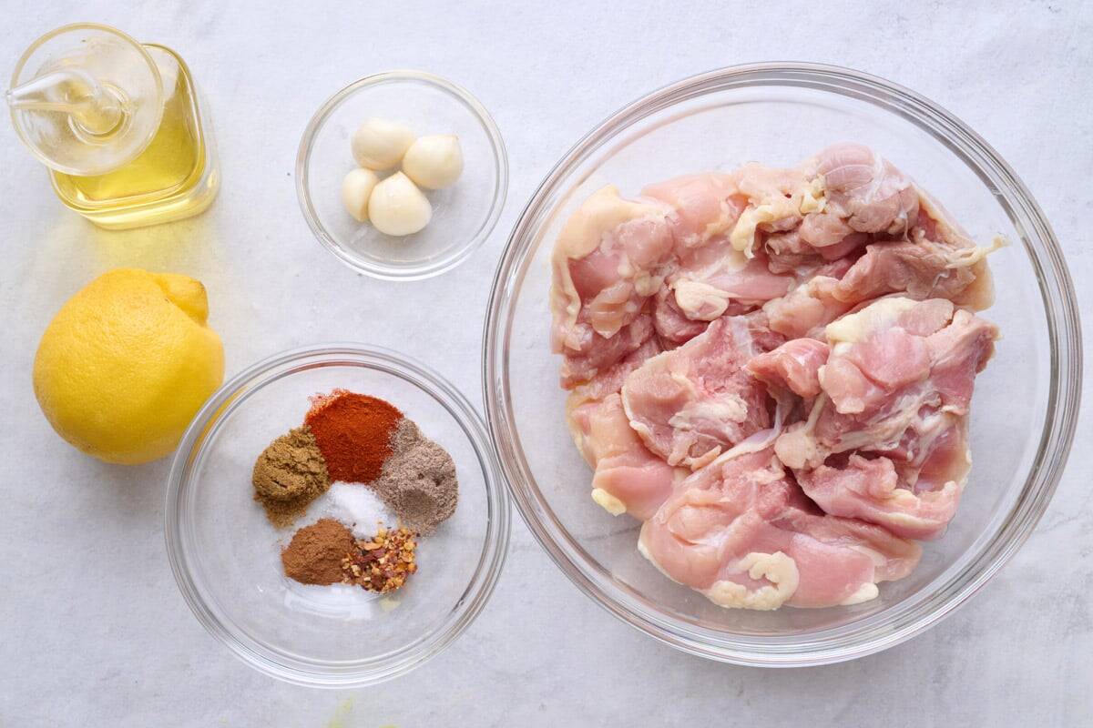 Ingredients for recipe: oil, lemon, spices, garlic, and chicken thighs.