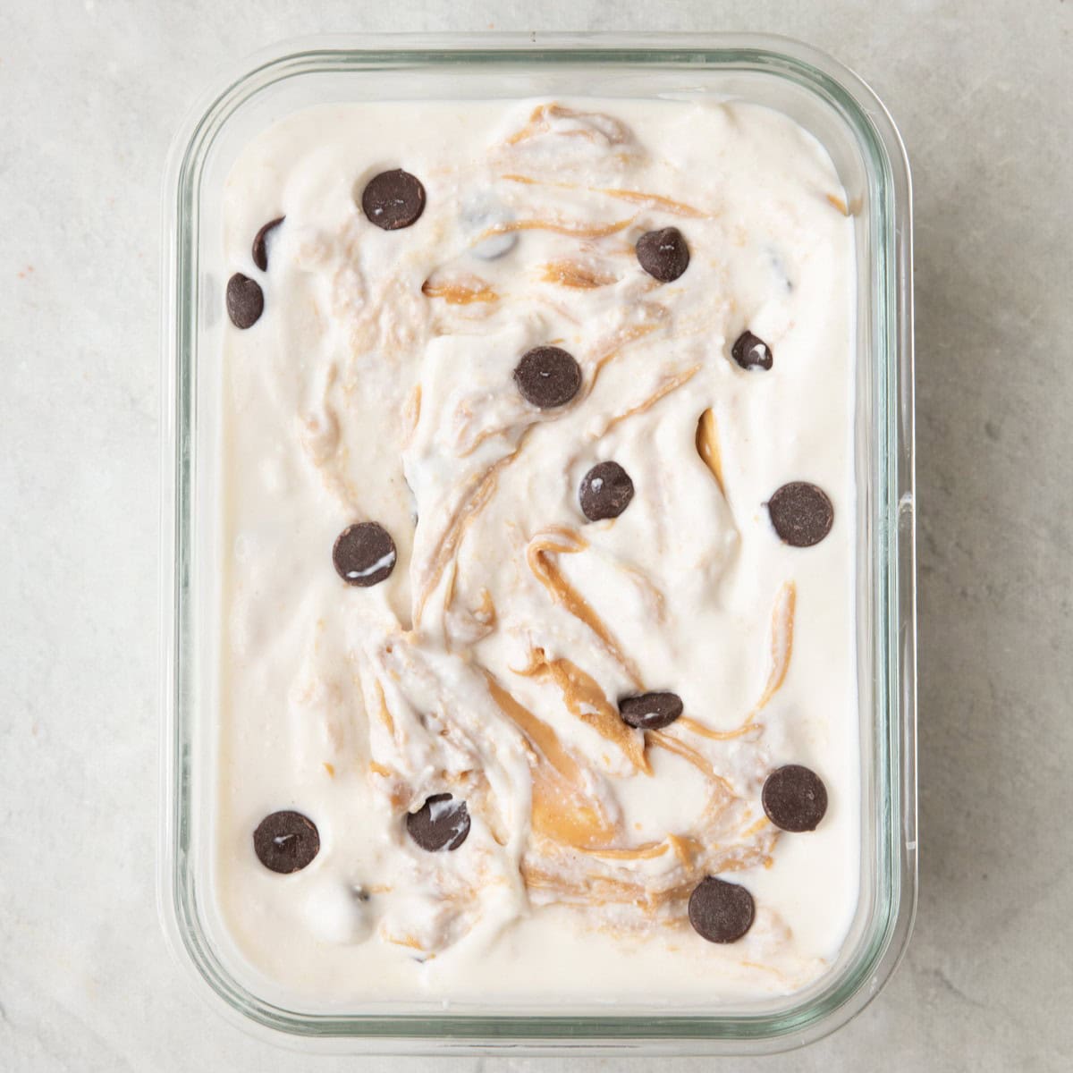 Peanut butter and chocolate mixture added to a small glass dish before freezing.