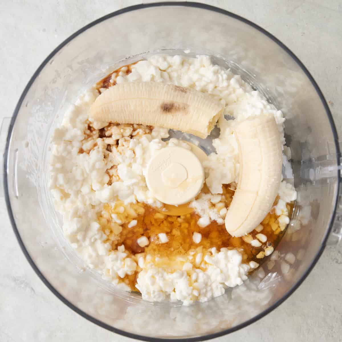 Cottage cheese, honey, banana and vanilla in a food processor before blending.