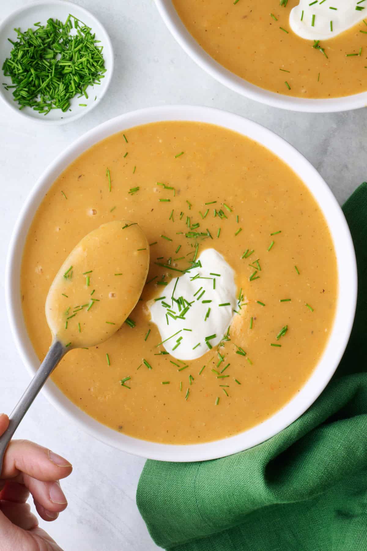 Spoon lifting up a bite of homemade creamy potato soup.
